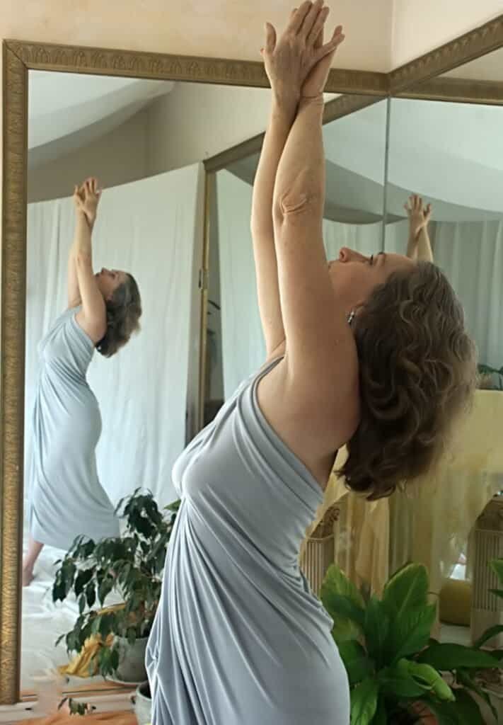 Dance-inspired portrait of a woman posing in a studio beside a large mirror
