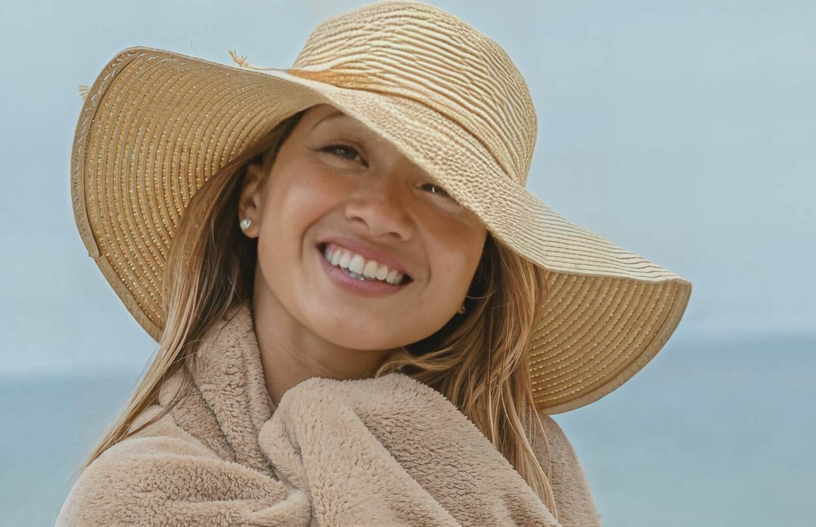 Natural outdoor portrait of a smiling woman wearing a wide-brimmed hat, photographed by Photos by Jairo