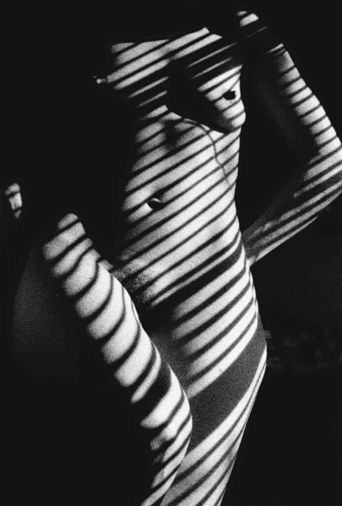 Artistic black and white portrait with striped light and shadow
