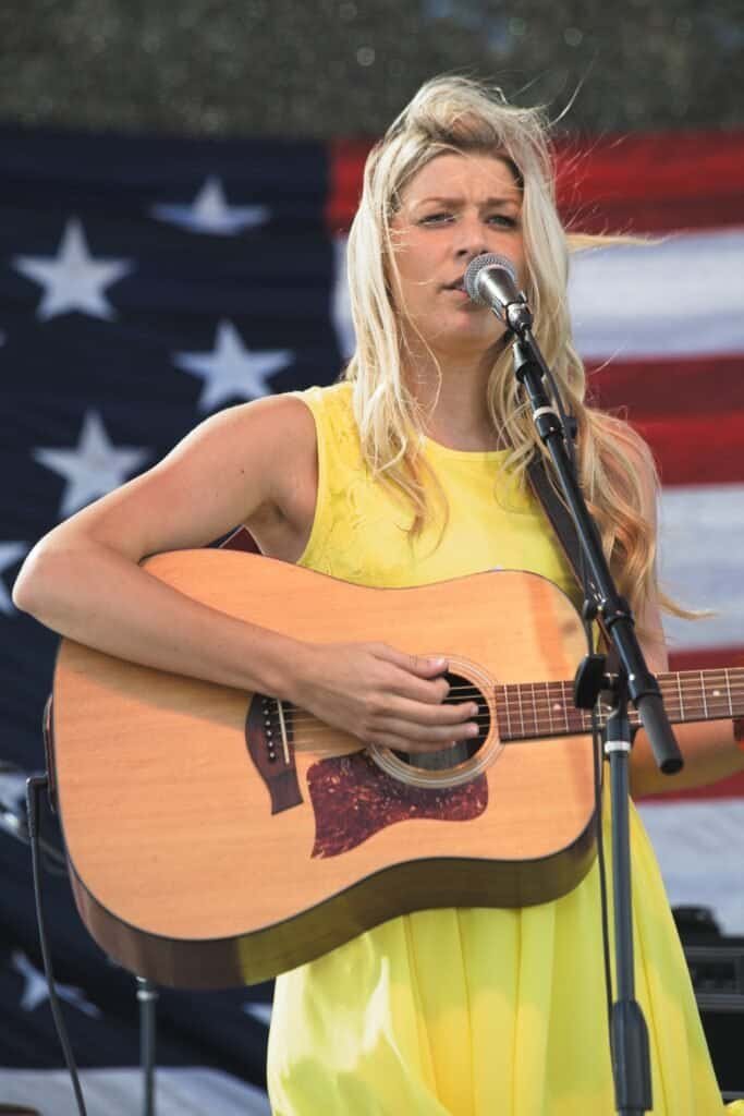 A Female singer, guitar player performing