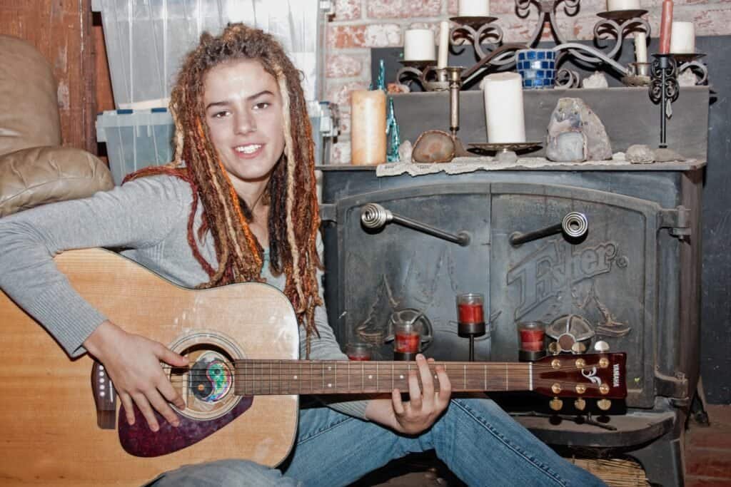 Young female playing guitar at her home